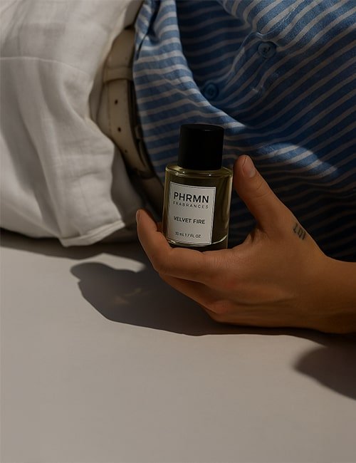 Hand hält PHRMN Velvet Fire Pheromon Parfum in entspannter Pose – stilvoll und modern